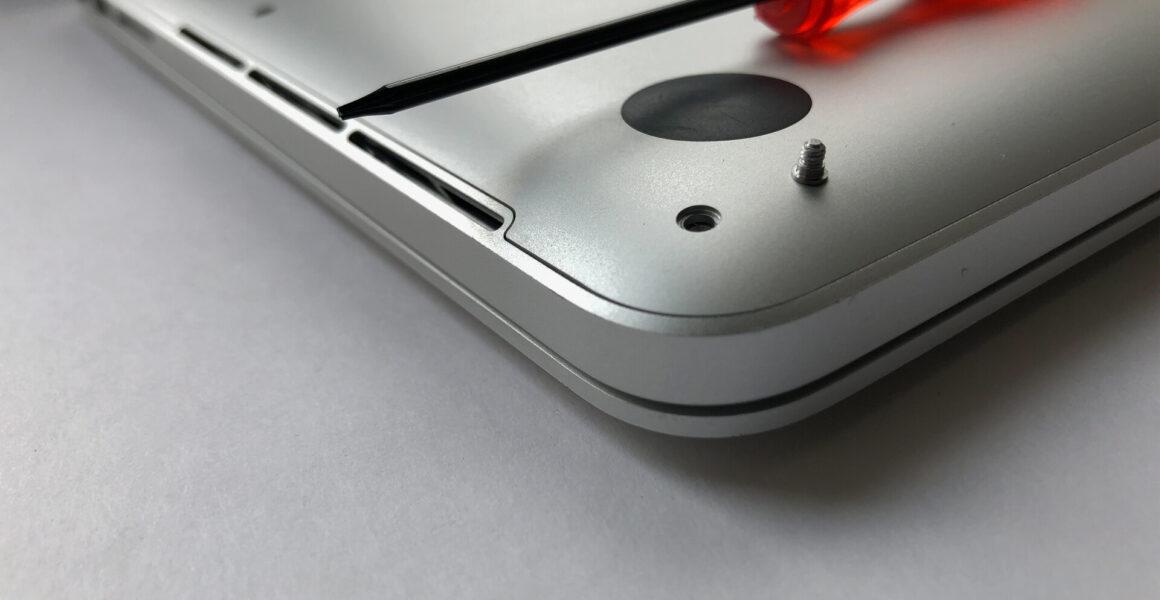 Rückseite des silbernen MacBook Pro 13 mit einem roten Schraubendreher